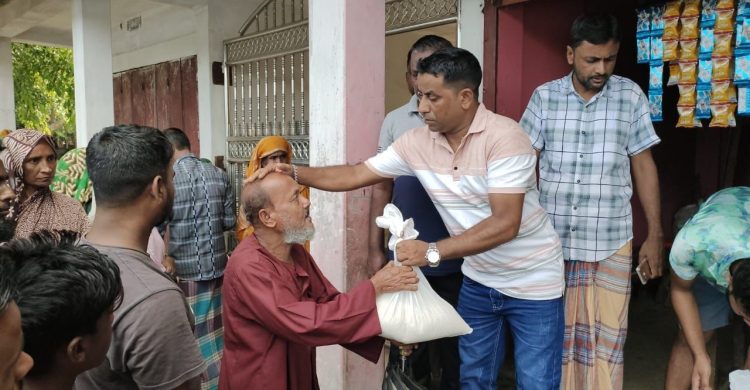 বন্যা দুর্গতদের মধ্যে ব্যবসায়ী  আবুবকরের চাল বিতরণ